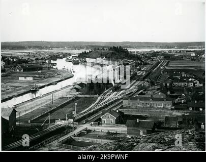 Blick auf Söderhamn und den State Line-Bahnhof und die Gegend von Bangård. Das Bahnhofshaus ist über den Dampfstrahl hinaus sichtbar. Im äußersten Teil von Bangården, rechts, ist die Lokomotive zu sehen, die zu dieser Zeit aus drei Lokomotiven bestand. Stockfoto