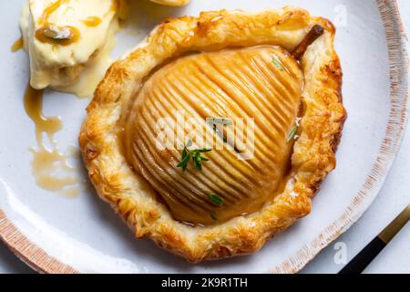 Hasselback-Birne im Blätterteig mit Vanilleeis Stockfoto
