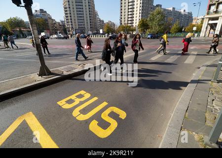 Bukarest, Rumänien - 17. Oktober 2022: Auf dem Platz der Vereinten Nationen in Bukarest, Rumänien, überqueren Fußgänger eine Straße mit einer Busspur. Dieses Bild ist für ed Stockfoto