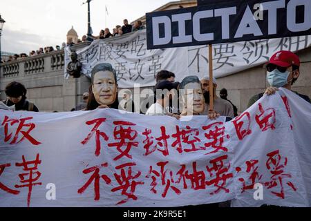 London, Großbritannien. 29. Oktober 2022. Während der Demonstration sahen die Demonstranten, wie sie Xi Jinping maskierten und ein Transparent hielten. Demonstranten der Kommunistischen Partei Chinas, darunter Hongkongers, Ugyhurs, Tibeter und chinesische Studenten aus den britischen Gemeinden, versammelten sich auf dem Trafalgar Square, um gegen das Totalitarismus-Regime der chinesischen Regierung unter den Regeln von Xi Jinping zu protestieren. (Foto von Hesther Ng/SOPA Images/Sipa USA) Quelle: SIPA USA/Alamy Live News Stockfoto