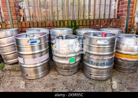 Leere Bierkegs aus Metall auf dem Boden vor einem Pub Stockfoto
