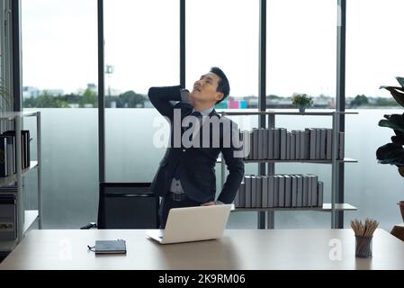 Asiatische Geschäftsmann im Büro entspannen, Stretching Arm-und Nackenmuskulatur , warten auf die Arbeit und Treffen. Stockfoto