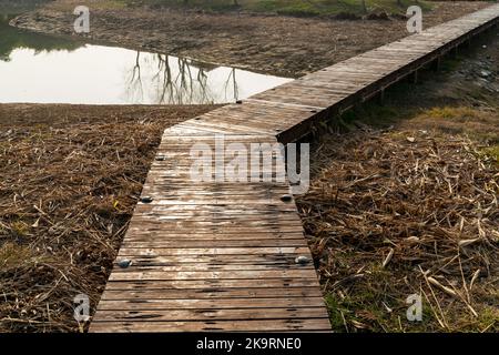 Holzbrücke über kleinen Fluss im Stadtpark Stockfoto