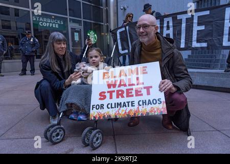 New York, USA. 29. Oktober 2022. Ein Paar mit ihrem Kind posiert mit einem Schild "SCHULD WALL STREET FÜR KLIMACHAOS" vor dem Hauptsitz des Finanzinvestitionsunternehmens BlackRock während einer "Occupy Park Avenue"-Protestaktion am 29. Oktober 2022 in New York City. Dutzende Klimaaktivisten mit einem großen Banner mit der Aufschrift „Occupy Park Avenue“ und Plakaten, die die fossile Energiewirtschaft anvisierten, marschierten entlang der Park Ave vom neuen Hauptsitz der JPMorgan Chase Bank zum Hauptsitz des Finanzinvestitionsunternehmens BlackRock, um gegen die Investitionen dieser Unternehmen in fossile Energieträger zu protestieren. Kredit: Ron Adar/Alamy Live Nachrichten Stockfoto