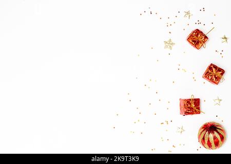 Weihnachtskonzept, Zusammenstellung von Dekorationen weihnachten festlich mit roten Goldkugeln und Geschenkbox. Stockfoto