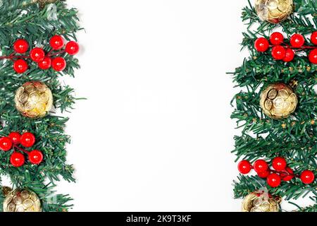 Dekoration weihnachtskonzept, Tannenzweige schmücken mit roten Beeren und goldenen Kugeln. Stockfoto