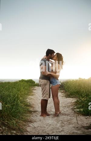 Genießen Sie jeden Moment der Romantik. Ein junges Paar, das einen romantischen Tag am Strand verbringt. Stockfoto