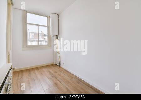 Interieur der leeren modernen Wohnung mit geometrischem Design mit Eingangstür und weißen Wänden und Parkettboden Stockfoto