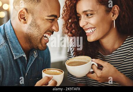 Sie passen perfekt dazu. Ein liebevolles junges Paar genießt ihr Date im Café. Stockfoto