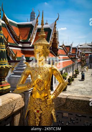 Eine goldene buddhistische Statue, eine Schutzstatue der Goldenen Stupa (Phra Si Ratana Chedi) neben dem Tempel des Smaragd-Buddha in Bangkok, Thailand. Stockfoto