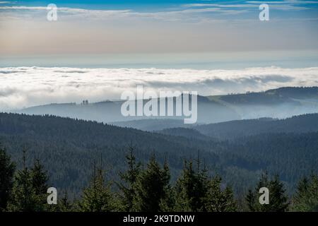 Blick vom Aussichtsturm auf den Berg Anenský vrch nach Westen, Eagle Mts., Tschechien. Herbstwetter mit Umkehrung und Nebel, Bergrücken steigen darüber. Stockfoto