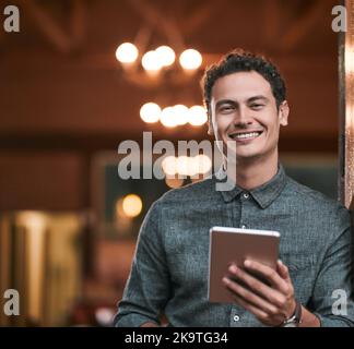 Glücklich, Teil dieses Geschäfts zu sein. Ein selbstbewusster junger Mann, der tagsüber auf einem digitalen Tablet in einer Bierbrauerei steht. Stockfoto