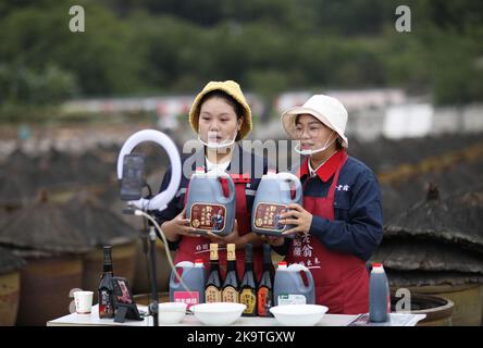 (221030) -- CHISHUI, 30. Oktober 2022 (Xinhua) -- zwei Frauen bewerben Essigprodukte per Livestream in einer Essigfabrik in Chishui, südwestlich der Provinz Guizhou, China, am 28. Oktober 2022. Chishui wird für seinen Sonnenessig gefeiert, der einen traditionellen Prozess der Herstellung beibehalten hat. Die Produktionstechniken des Chishui-Essigs, die den Sonnenanbungsprozess kennzeichnen, wurden 2009 als immaterielles Kulturerbe der Provinz Guizhou und 2021 als nationales Kulturerbe aufgeführt. Der Essig ist bekannt für seinen einzigartigen Geschmack auch wegen seiner bewährten Rezept, das einige pflanzliche Medikamente enthalten. Die lokale Regierung Stockfoto