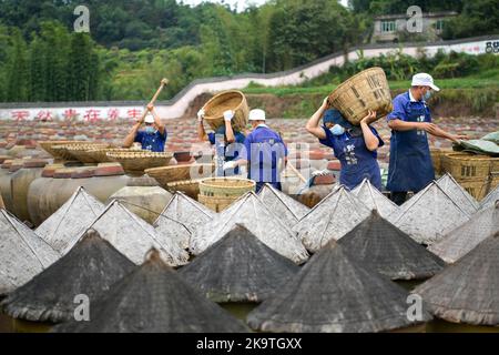 (221030) -- CHISHUI, 30. Oktober 2022 (Xinhua) -- Arbeiter bewegen Rohstoffe auf dem Sonnenfeld einer Essigfabrik in Chishui, südwestlich der Provinz Guizhou, China, am 28. Oktober 2022. Chishui wird für seinen Sonnenessig gefeiert, der einen traditionellen Prozess der Herstellung beibehalten hat. Die Produktionstechniken des Chishui-Essigs, die den Sonnenanbungsprozess kennzeichnen, wurden 2009 als immaterielles Kulturerbe der Provinz Guizhou und 2021 als nationales Kulturerbe aufgeführt. Der Essig ist bekannt für seinen einzigartigen Geschmack auch wegen seiner bewährten Rezept, das einige pflanzliche Medikamente enthalten. Die lokale Regierung pi Stockfoto