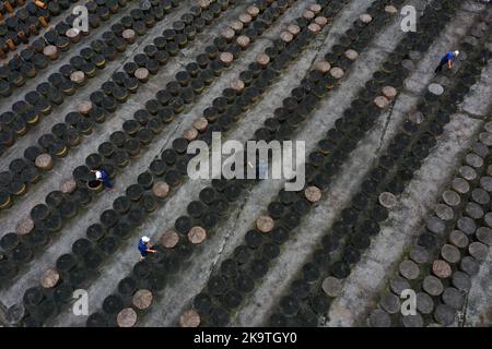 (221030) -- CHISHUI, 30. Oktober 2022 (Xinhua) -- Dieses Luftfoto vom 28. Oktober 2022 zeigt Arbeiter, die auf dem Sonnenfeld einer Essigfabrik in Chishui, südwestlich der Provinz Guizhou, arbeiten. Chishui wird für seinen Sonnenessig gefeiert, der einen traditionellen Prozess der Herstellung beibehalten hat. Die Produktionstechniken des Chishui-Essigs, die den Sonnenanbungsprozess kennzeichnen, wurden 2009 als immaterielles Kulturerbe der Provinz Guizhou und 2021 als nationales Kulturerbe aufgeführt. Der Essig ist bekannt für seinen einzigartigen Geschmack auch wegen seiner bewährten Rezept, das einige pflanzliche Medikamente enthalten. Stockfoto