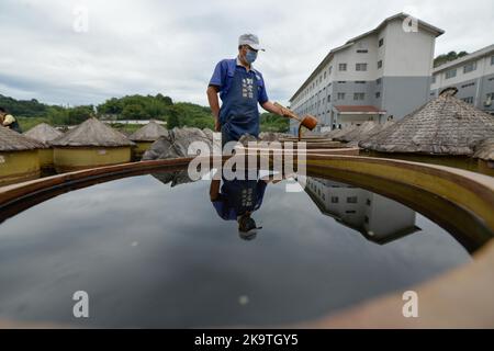 (221030) -- CHISHUI, 30. Oktober 2022 (Xinhua) -- Ein Arbeiter überprüft die Reife von Essig in einer Essigfabrik in Chishui, südwestlich von Chinas Provinz Guizhou, 28. Oktober 2022. Chishui wird für seinen Sonnenessig gefeiert, der einen traditionellen Prozess der Herstellung beibehalten hat. Die Produktionstechniken des Chishui-Essigs, die den Sonnenanbungsprozess kennzeichnen, wurden 2009 als immaterielles Kulturerbe der Provinz Guizhou und 2021 als nationales Kulturerbe aufgeführt. Der Essig ist bekannt für seinen einzigartigen Geschmack auch wegen seiner bewährten Rezept, das einige pflanzliche Medikamente enthalten. Der lokalen Regierung Stockfoto