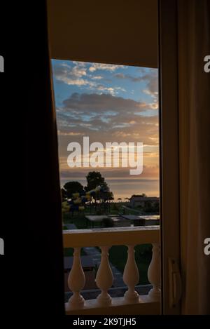 Sonnenaufgang Von Der Insel Korfu Mit Blick Auf Die Berge Der Balkanhalbinsel Griechenlands, Moraitika, Korfu, Griechenland. Im Vordergrund Ausgang zum Balkon und Geländer Stockfoto