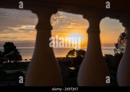 Sonnenaufgang Von Der Insel Korfu Mit Blick Auf Die Berge Der Balkanhalbinsel Griechenlands, Moraitika, Korfu, Griechenland. Im Vordergrund Sind Balcongeländer Stockfoto