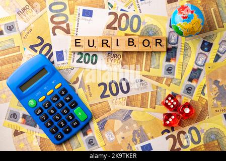 Wort EURIBOR ist in Holzbuchstaben auf dem Hintergrund von 200 Euro Banknoten, Globus, Rechner und Würfel geschrieben. Kopieren Einfügen. Stockfoto