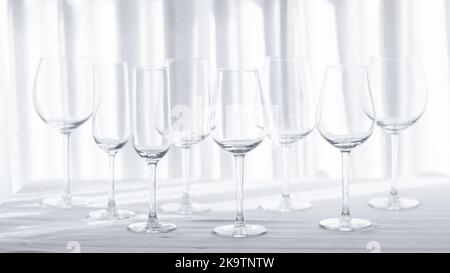 Mehrere Gläser für verschiedene Weinsorten auf der weißen Tischdecke. Stockfoto