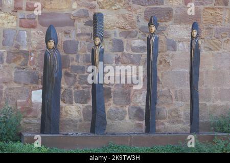 Vier schlanke braune Skulpturen aus Holz an der Wand des Wasserschlosses in Bad Vilbel, Holzschnitzerei, Gesichter, Handarbeit, dünn, Anmutig, Figuren Stockfoto