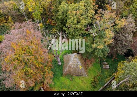 Holle, Deutschland. 30. Oktober 2022. Die Mausoleum-Pyramide des Grafen Ernst zu Münster aus dem Jahr 1839 steht zwischen herbstlich gefärbten Bäumen auf dem Laves-Kulturweg im Landkreis Hildesheim. Das Grab wurde von Georg Ludwig Friedrich Laves, dem Architekten des Königreichs Hannover, als ägyptische Steilpyramide entworfen. (Mit einer Drohne aufgenommen) Quelle: Swen Pförtner/dpa/Alamy Live News Stockfoto