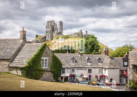 DORSET, Großbritannien - 06. Juli 2022. Historisches Dorf mit Burgruinen von Corfe im Hintergrund. Haupttouristenattraktion im Purbeck-Viertel von Dorset, Großbritannien Stockfoto