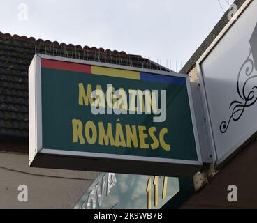 Ladenschild in Bletchley: 'Rumänischer Shop' mit den Farben der rumänischen Flagge an der Spitze. Das Schild hat einen Vogelspieß am oberen Rand. Stockfoto