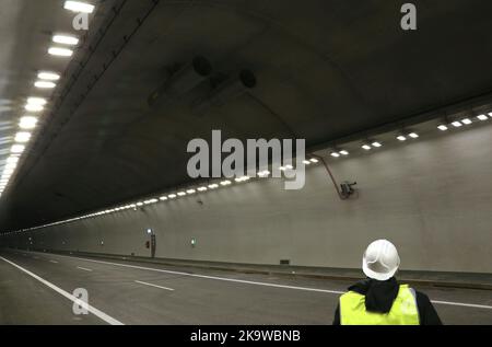 Naprawa. Malopolska. Polen. Straßentunnel unter einem Hügel. Alleinerziehender Mann im Helm. Stockfoto