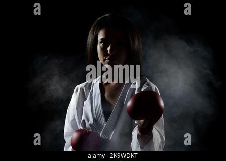 Schönes Mädchen Ausübung Karate Pose vor Nebel Hintergrund Stockfoto