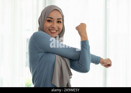 Portrait schöne junge muslimische asiatische Frau, die zu Hause Sport macht. Gesunder Lebensstil und gute Wellness-Konzepte. Stockfoto