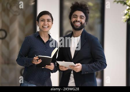 Porträt zweier ambitionierter indischer Kollegen, die im Arbeitsraum posieren Stockfoto