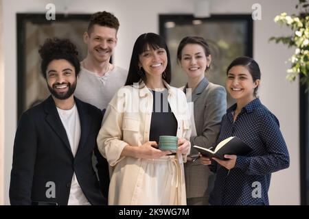 Porträt verschiedener Geschäftsleute, die im Büroflur zusammenstehen Stockfoto