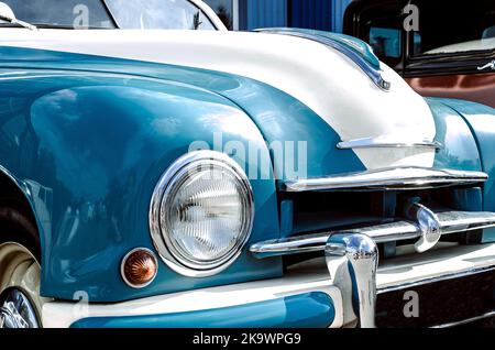 Farbdetail auf dem Scheinwerfer eines Oldtimers, Retro-Armaturenbrett Innenraum. Ansicht des Lenkrads und des Armaturenbretts eines alten Vintag-Autos. Stockfoto