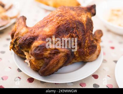 Ganz gebratenes Huhn auf einem Teller Stockfoto