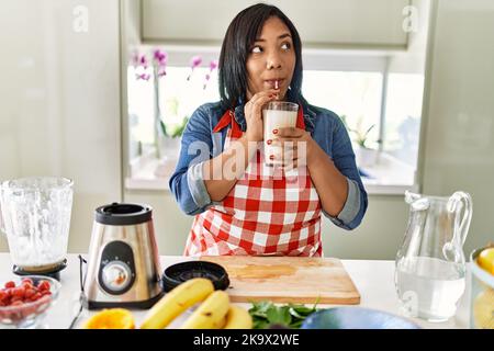 Hispanische Brünette Frau trinkt frischen Obst-Smoothie in der Küche Stockfoto