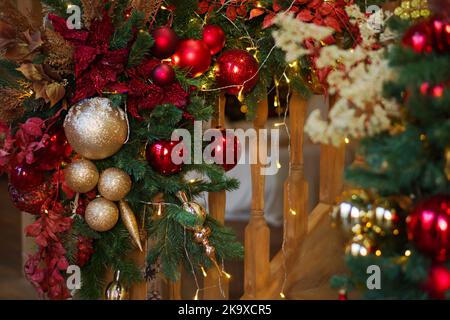 Close up image Geländer von Holztreppe geschmückt Weihnachten mit bunten Glaskugeln, Girlande, Mistel und Fichtenzweige. Home Weihnachten A Stockfoto