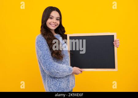 Kleines Mädchen Teenager mit Tafeln. Teenager Schulmädchen halten Tafel für Kopieplatz, Schulverkauf. Glücklicher Teenager, positive und lächelnde Emotionen Stockfoto