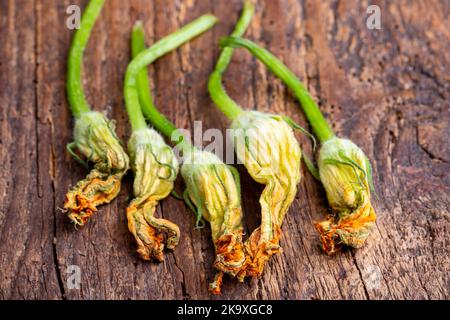 Zucchini blüht auf dunklem Holz Stockfoto