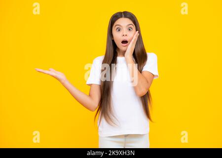 Wow, es ist unglaublich. Schockiert Teenager Kind zeigt beiseite auf den Kopierraum. Teen Mädchen zeigt mit zwei Händen und Fingern zur Seite. Begeistert Stockfoto