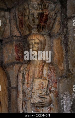 Der heilige Pastor, ein 13-jähriger Schuljunge, der von den Römern in Spanien martyriert wurde. Säulenstatue im Nordportal der Basilika Saint-Just in Valcabrère, Occitanie, Frankreich. Der Kopf des heiligen Pastors unterstützt eine romanisch geformte Hauptstadt, die seine Festnahme und Folter vor der Hinrichtung grafisch veranschaulicht. Sein Bruder Just oder Justus, im Alter von nur sieben Jahren, wurde mit ihm wegen der Verurteilung der römischen Religion martyriert. Stockfoto