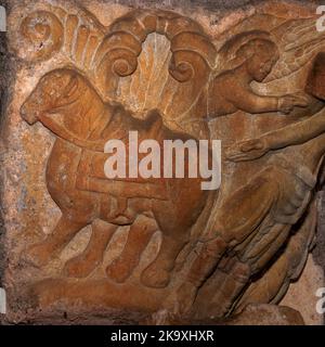 Ein geduldiges Pferd wartet darauf, dass St. Helena in seinem Sattel sitzt und die Zügel nimmt: Detail der romanischen Hauptstadt aus dem späten 1100s. Jh. im Nordportal der Basilika St. in Valcabrère, im französischen Westen, mit einer Darstellung der römischen Kaiserin Helena, der Mutter des christlichen Kaiser Konstantin I., die sich auf ihre Pilgerreise nach Jerusalem begeben hat, um das wahre Kreuz zu finden. Stockfoto