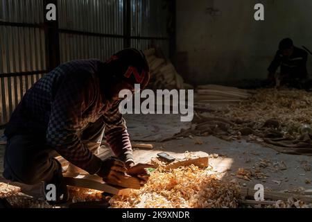 Arbeiter Formen Weiden mit Werkzeugen zur Holzbearbeitung, um Cricket-Fledermäuse in einer Fabrik in Sangam herzustellen. Seit Jahren gilt Kashmiri-Weide als dem Holz der englischen Weide, die immer noch ein nahezu Monopol über die globale Cricket-Fledermaus-Industrie besitzt, erheblich unterlegen und hat vor kurzem einen bedeutenden Ausflug in die internationale Cricket-Welt unternommen, der von einigen Spielern bei der Weltmeisterschaft T20 und der verwendet wurde Legends Cricket League. In den letzten vier Jahren haben 25 Geschäftseinheiten der Fledermausherstellungsindustrie in Halmulla und Sangam im Bijbehara-Gürtel aufgrund mangelnder Nachfrage geschlossen. Stockfoto