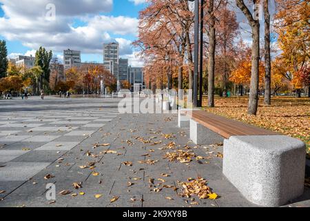 Herbst bunte Stadtarchitektur. Straßenbank in modernen Erholungsgebiet mit Brunnen auf Freiheit oder Svobody Square in der Nähe von Derzhprom konstruktivistischen bui Stockfoto