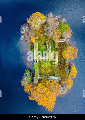 Luftaufnahme der Herbstfarben und Wolkenspiegelungen auf der zerstörten Burg auf der Insel am Loch an Eilein im Rothiemurchus Estate, Cairngorms National Park nea Stockfoto