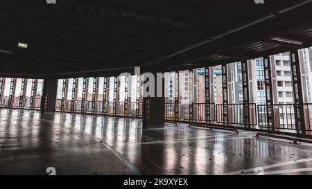 Blick von leeren Parkplätzen in mehrstufigen Parkplatz auf moderne Wohngebäude, Innenstadt-Architektur in den Abend im Herbst Charkiw, Ukraine Stockfoto