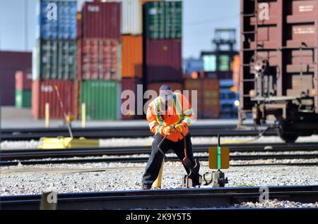 Franklin Park, Illinois, USA. Ein Eisenbahner wirft manuell einen Yard-Schalter auf eine Bleischiene, um eine Lokomotive auf eine andere Schiene zu bringen. Stockfoto