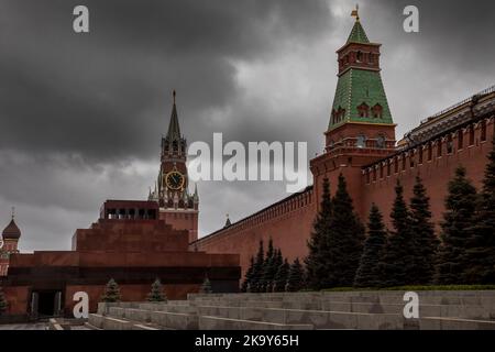 Blick auf den Roten Platz in Moskau, Lenins Mausoleum, den Spasskaya-Turm an einem Herbsttag und bewölkten Himmel Stockfoto