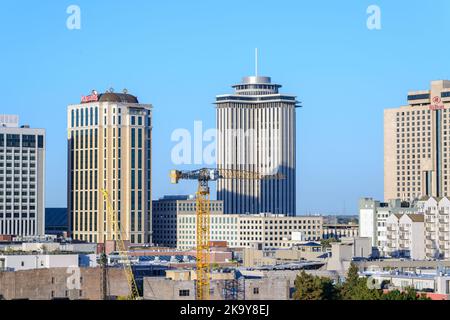 NEW ORLEANS, LA, USA - 25. OKTOBER 2022: Stadtbild mit Harrah's Hotel, Hilton Hotel, dem Four Seasons Hotel und einem Kran, der über einer Innenstadt schwebt Stockfoto