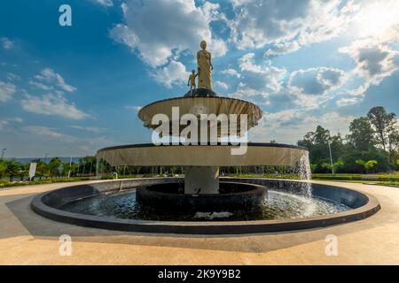 Kigali, Ruanda - 19 2022. August: Ein Brunnen mit einer Statue einer Frau und eines Kindes in traditioneller ruandischer Kleidung. Stockfoto